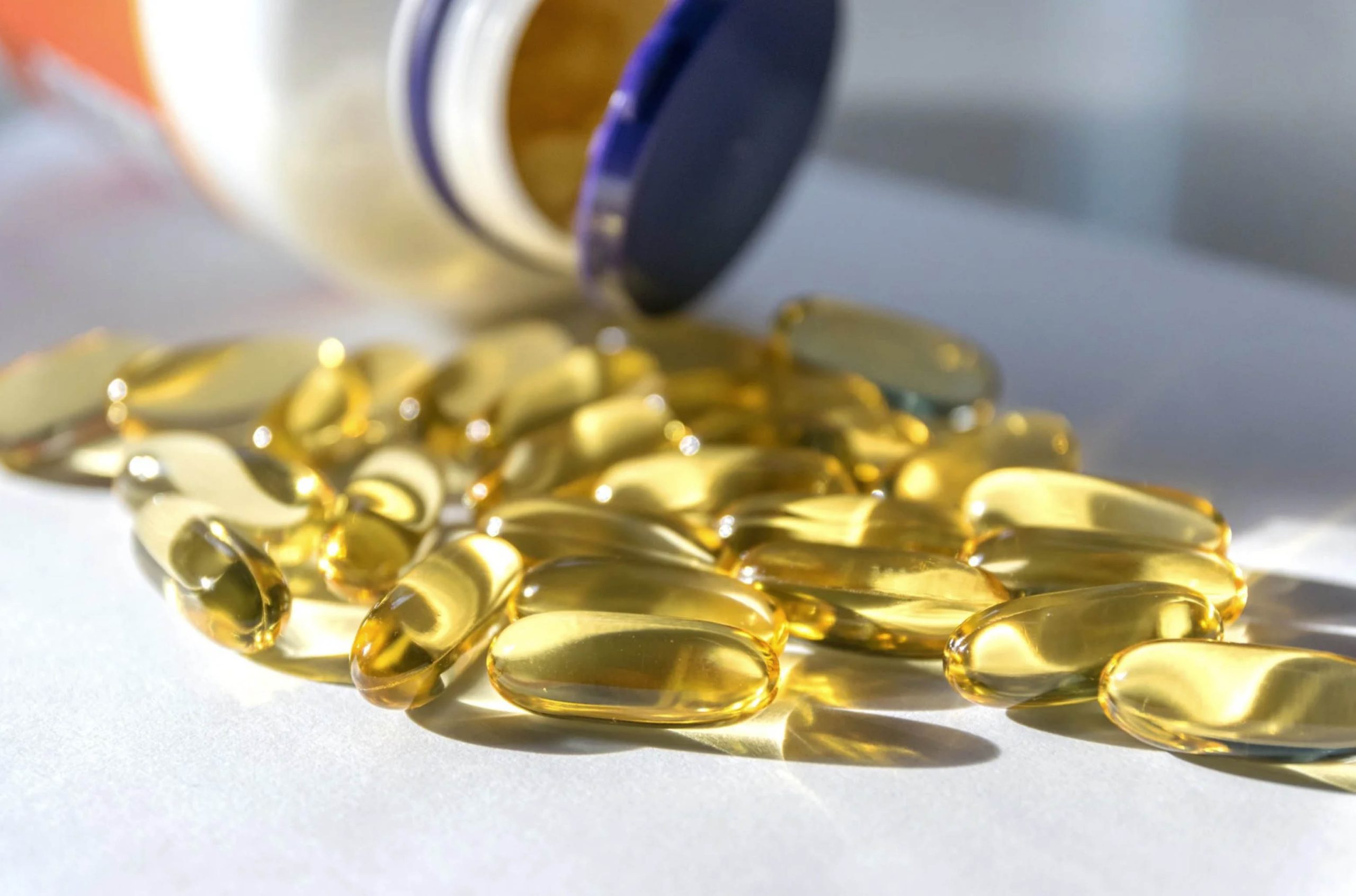 ACGrace - A bottle of vitamin d capsules on a white surface.