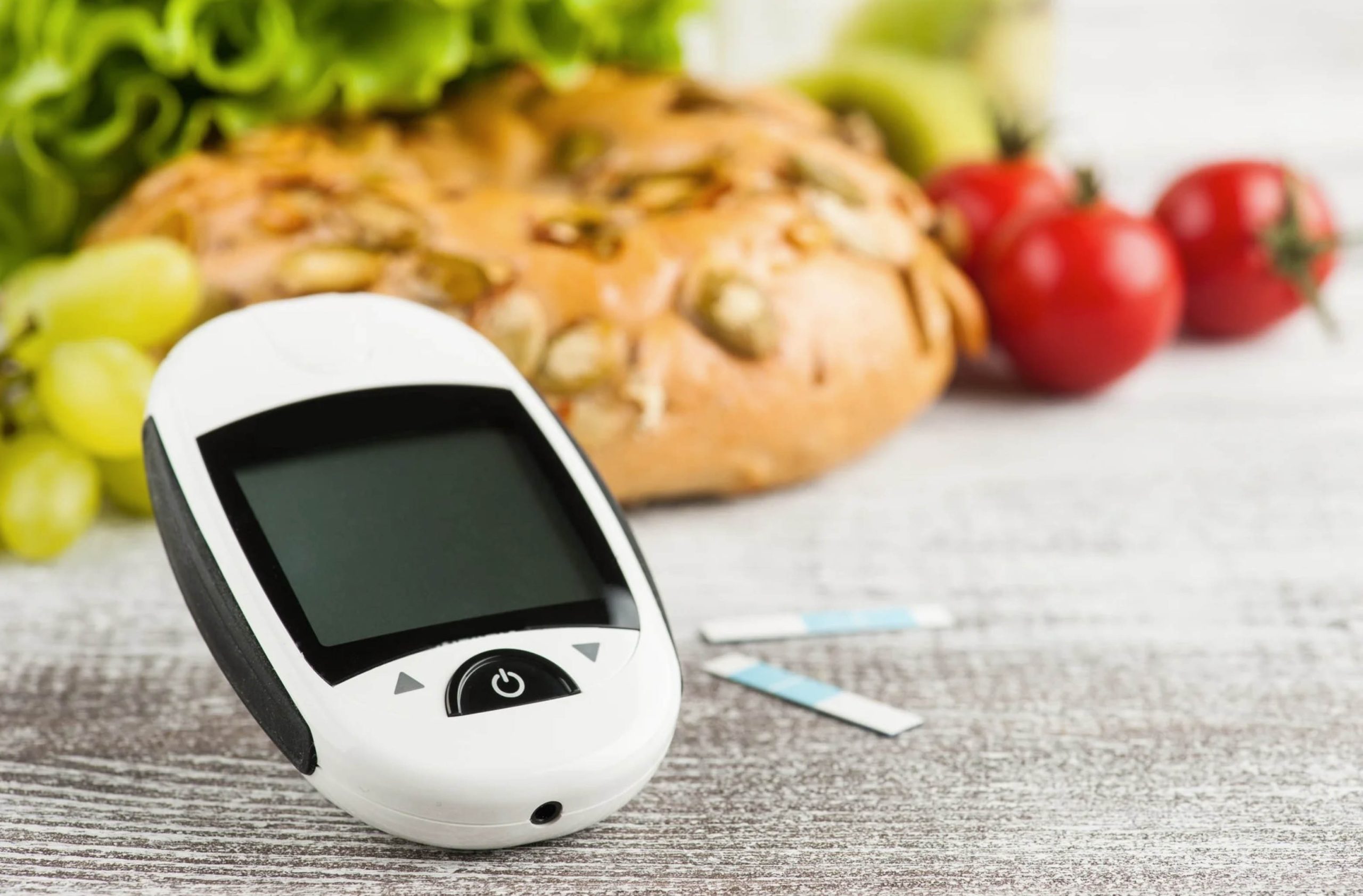 ACGrace - A digital glucose monitor next to fruits and vegetables.