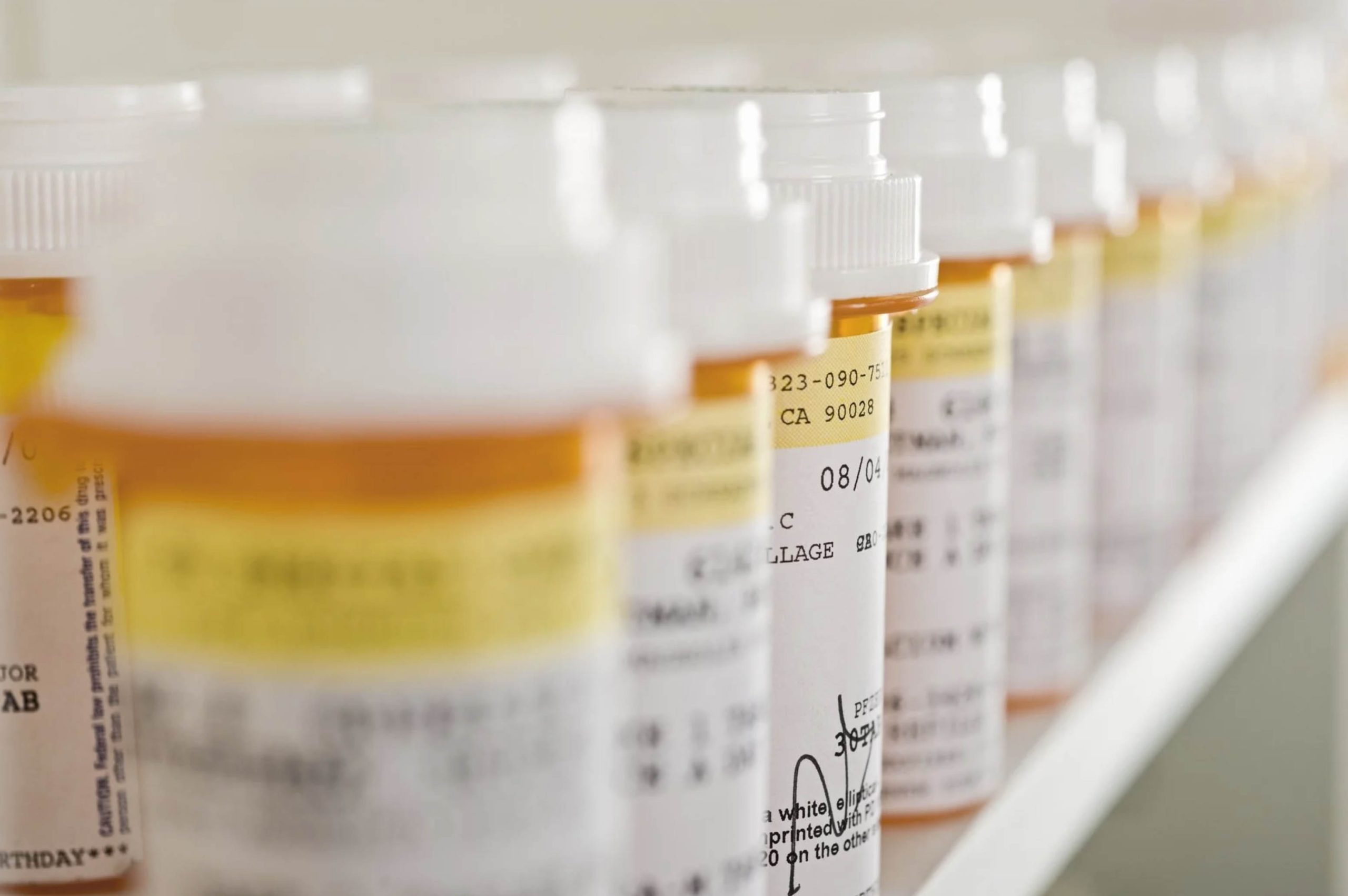 ACGrace - Many prescription bottles are lined up on a shelf.