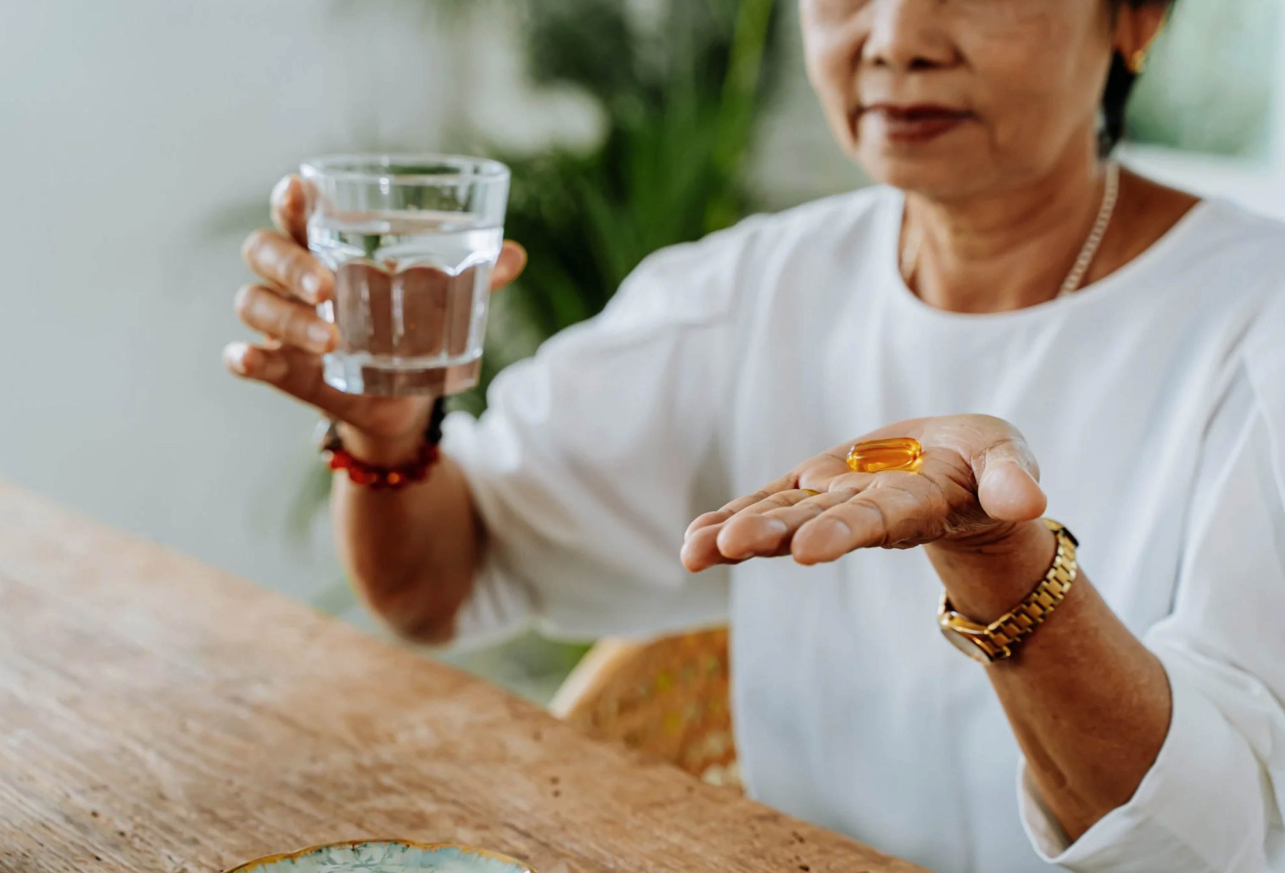 ACGrace - An asian woman is holding a glass of water and a pill.
