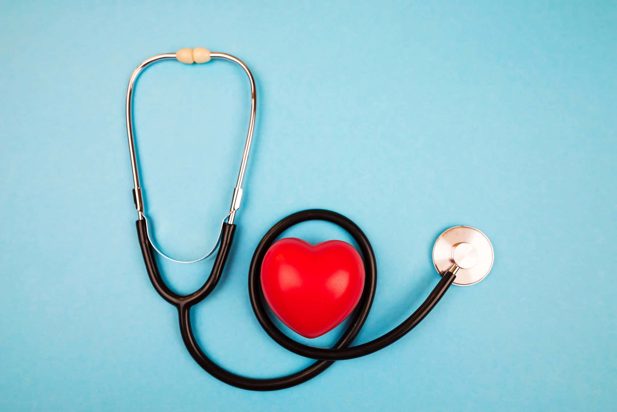 ACGrace - Stethoscope arranged around a red heart-shaped object on a blue background.